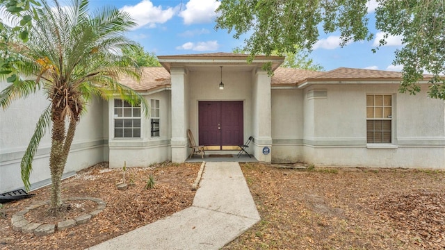 7311 Briarbay Loop, Lakeland, FL 33810 - doorway to property with stucco siding and roof with shingles