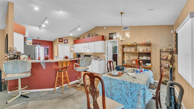 7311 Briarbay Loop, Lakeland, FL 33810 - dining area with lofted ceiling, a chandelier, baseboards, light colored carpet, and rail lighting