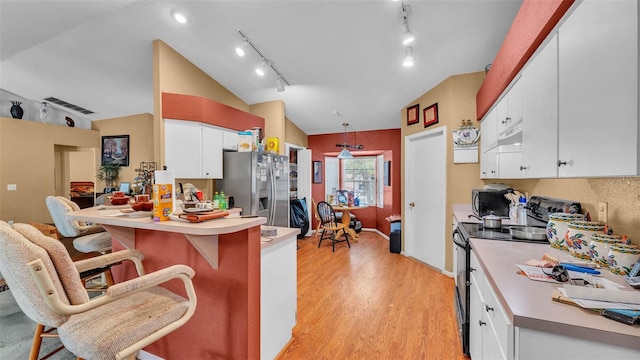 7311 Briarbay Loop, Lakeland, FL 33810 - kitchen featuring stainless steel appliances, lofted ceiling, white cabinets, a peninsula, and a breakfast bar