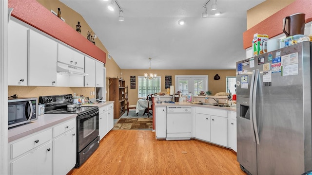 7311 Briarbay Loop, Lakeland, FL 33810 - kitchen with stainless steel appliances, under cabinet range hood, lofted ceiling, track lighting, and light wood finished floors