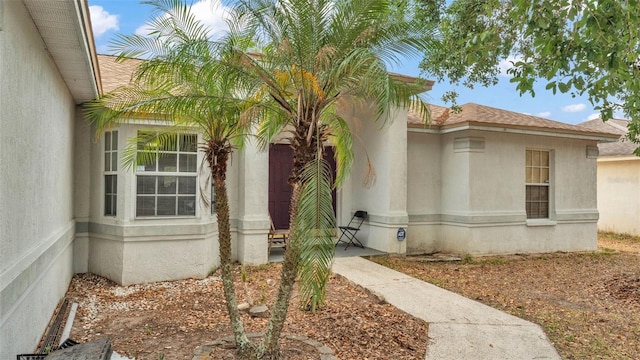 7311 Briarbay Loop, Lakeland, FL 33810 - view of exterior entry featuring stucco siding and a shingled roof