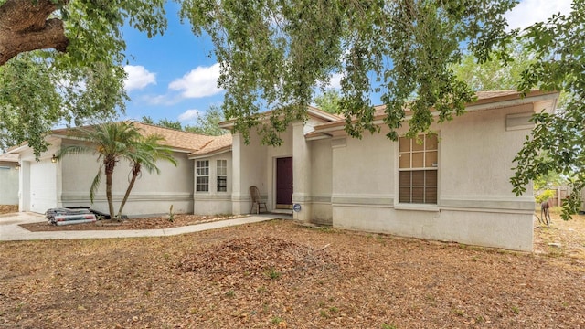 7311 Briarbay Loop, Lakeland, FL 33810 - view of front of house with an attached garage, stucco siding, and driveway
