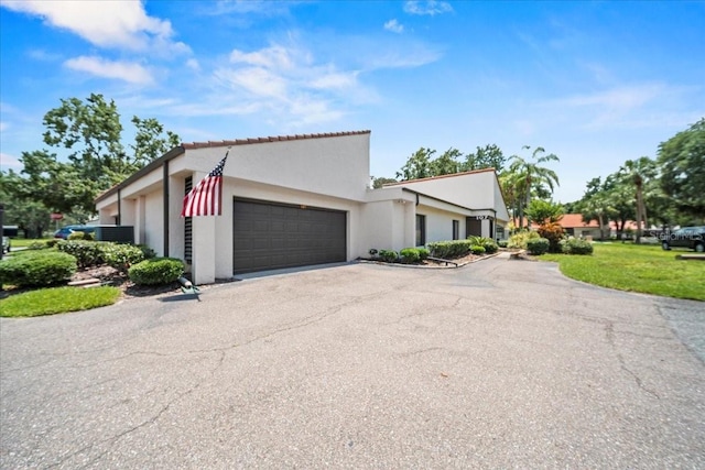 107 Seville Ct N, Plant City, FL 33566 - view of front of house with a garage, stucco siding, asphalt driveway, and a front yard