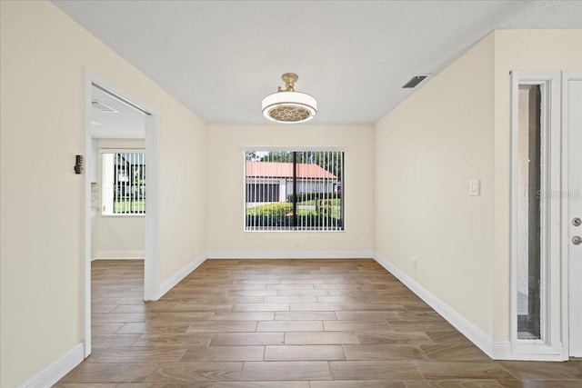 107 Seville Ct N, Plant City, FL 33566 - empty room featuring wood finished floors, baseboards, and a textured ceiling