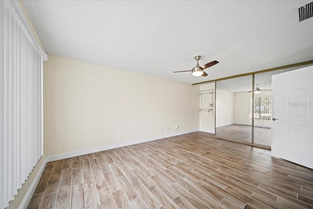 107 Seville Ct N, Plant City, FL 33566 - unfurnished bedroom with light wood-type flooring, a textured ceiling, a closet, and baseboards
