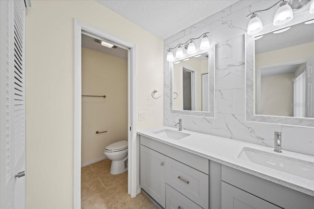 107 Seville Ct N, Plant City, FL 33566 - bathroom with double vanity, toilet, a textured ceiling, and tile patterned floors
