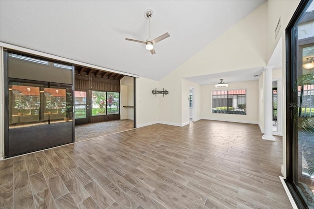 107 Seville Ct N, Plant City, FL 33566 - unfurnished living room featuring healthy amount of natural light, decorative columns, high vaulted ceiling, baseboards, and a ceiling fan