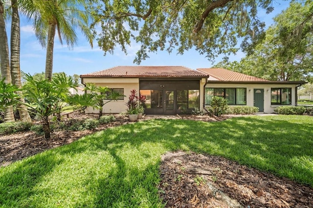 107 Seville Ct N, Plant City, FL 33566 - back of house with french doors, a lawn, a tile roof, and stucco siding