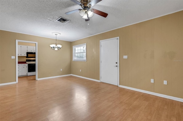 3427 S Polk Ave, Lakeland, FL 33803 - empty room featuring light wood-style flooring, a chandelier, a ceiling fan, a textured ceiling, and baseboards