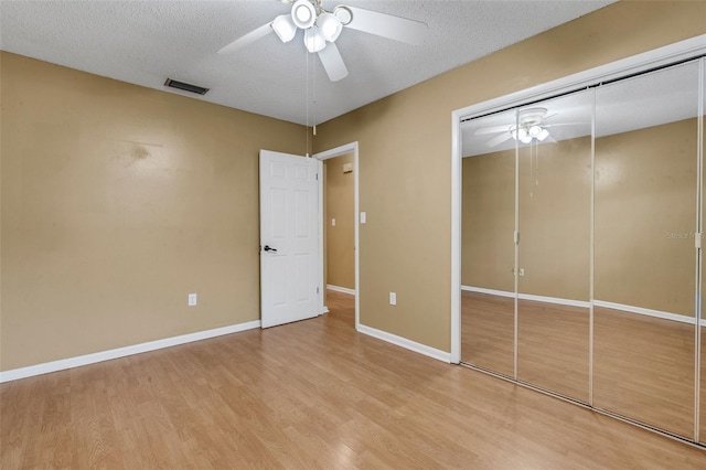 3427 S Polk Ave, Lakeland, FL 33803 - unfurnished bedroom featuring light wood-style flooring, a closet, a textured ceiling, ceiling fan, and baseboards