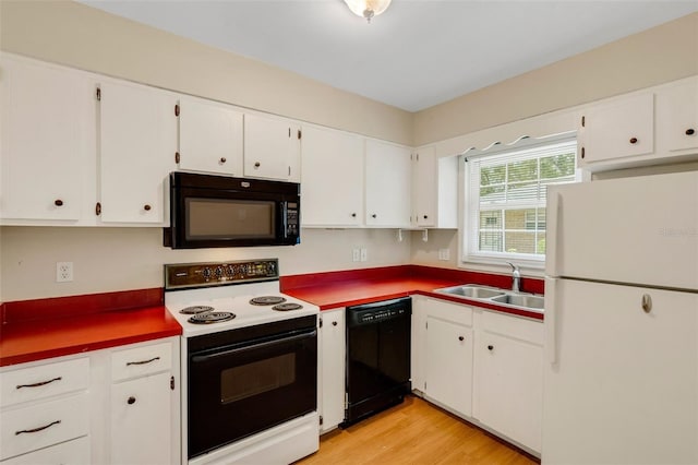 3427 S Polk Ave, Lakeland, FL 33803 - kitchen featuring black appliances, a sink, white cabinets, and light wood-style flooring