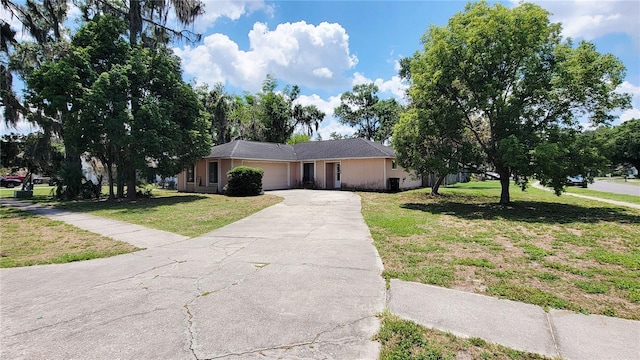 ranch-style house with an attached garage, a front yard, and driveway