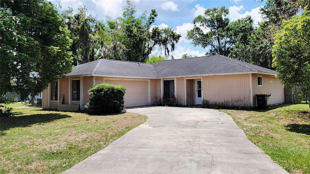 ranch-style home featuring driveway, a front yard, and an attached garage