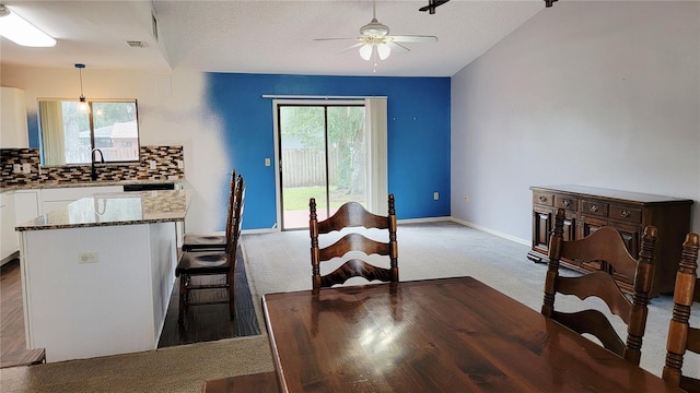 kitchen featuring white cabinetry, stone countertops, ceiling fan, carpet flooring, and tasteful backsplash