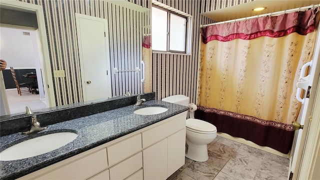 bathroom with wallpapered walls, toilet, double vanity, and curtained shower
