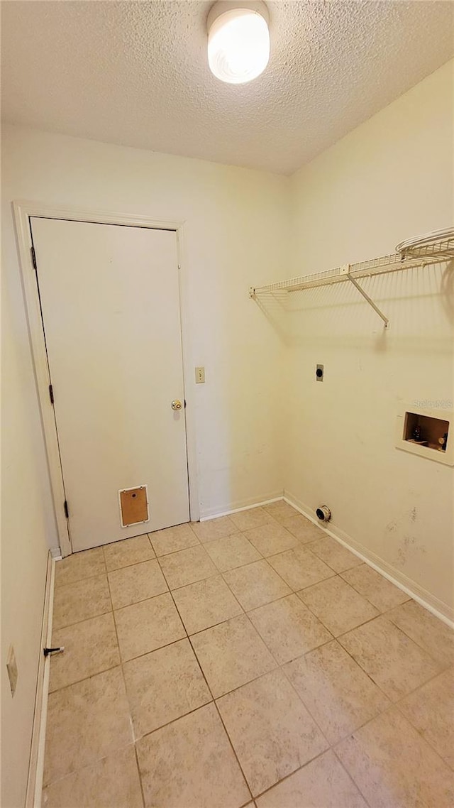 laundry area featuring washer hookup, light tile patterned flooring, hookup for an electric dryer, a textured ceiling, and baseboards