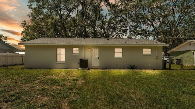 3829 Abbott Ln, Lakeland, FL 33810 - back of house at dusk with concrete block siding, cooling unit, roof with shingles, and a gate