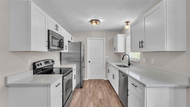 3829 Abbott Ln, Lakeland, FL 33810 - kitchen with appliances with stainless steel finishes, a sink, light wood-style floors, white cabinets, and light stone countertops