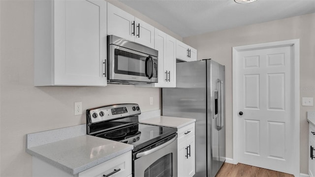 3829 Abbott Ln, Lakeland, FL 33810 - kitchen with appliances with stainless steel finishes, white cabinetry, light wood-type flooring, and light stone counters