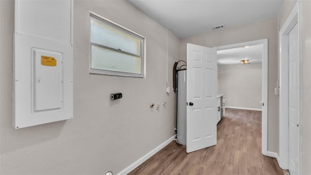 3829 Abbott Ln, Lakeland, FL 33810 - laundry room with electric panel, light wood finished floors, baseboards, and gas water heater