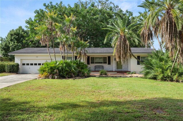 509 Rob Roy St, Lakeland, FL 33813 - ranch-style house with a porch, driveway, an attached garage, and a front lawn