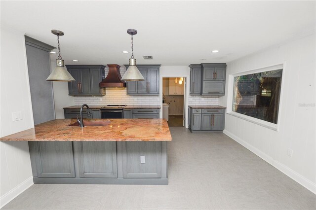 509 Rob Roy St, Lakeland, FL 33813 - kitchen with a sink, custom range hood, a peninsula, decorative backsplash, and recessed lighting