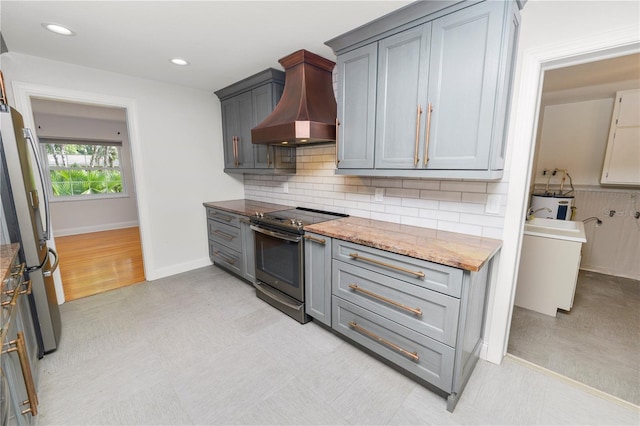 509 Rob Roy St, Lakeland, FL 33813 - kitchen with stainless steel appliances, custom range hood, backsplash, gray cabinetry, and recessed lighting