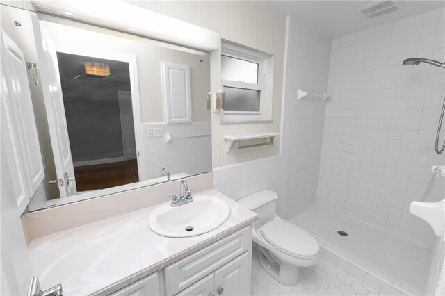 509 Rob Roy St, Lakeland, FL 33813 - full bath featuring a tile shower, vanity, toilet, tile patterned flooring, and tile walls