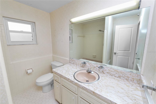 509 Rob Roy St, Lakeland, FL 33813 - bathroom featuring vanity, toilet, a wainscoted wall, tile patterned floors, and tile walls
