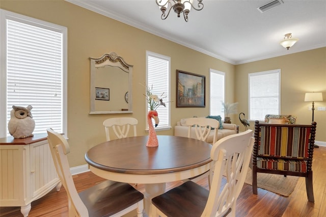 2731 Coventry Ave, Lakeland, FL 33803 - dining area with light wood-style floors, ornamental molding, baseboards, and a chandelier