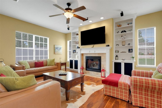 2731 Coventry Ave, Lakeland, FL 33803 - living room featuring wood finished floors, a ceiling fan, built in features, a tile fireplace, and recessed lighting
