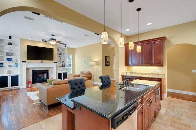 2731 Coventry Ave, Lakeland, FL 33803 - kitchen featuring arched walkways, appliances with stainless steel finishes, a sink, ceiling fan, and dark stone countertops