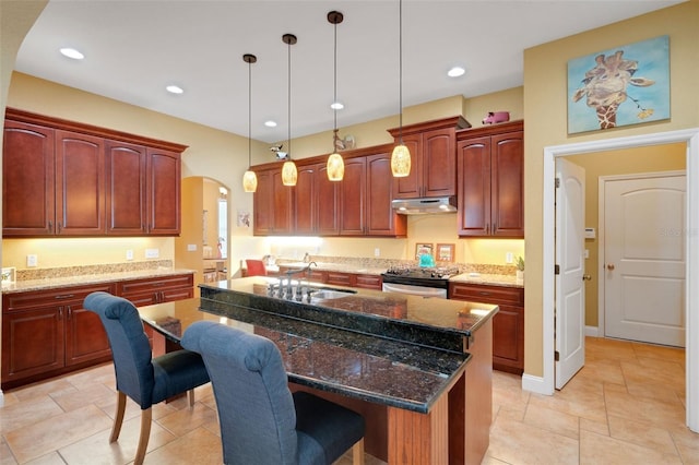 2731 Coventry Ave, Lakeland, FL 33803 - kitchen with a sink, arched walkways, under cabinet range hood, a breakfast bar, and hanging light fixtures