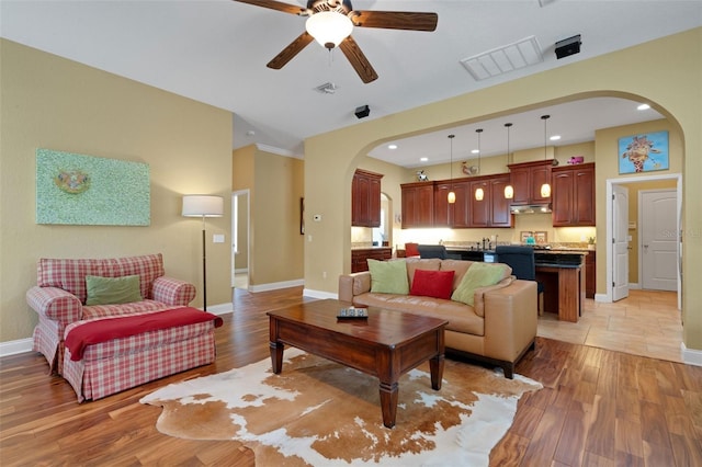 2731 Coventry Ave, Lakeland, FL 33803 - living room with arched walkways, ceiling fan, baseboards, light wood-style flooring, and recessed lighting
