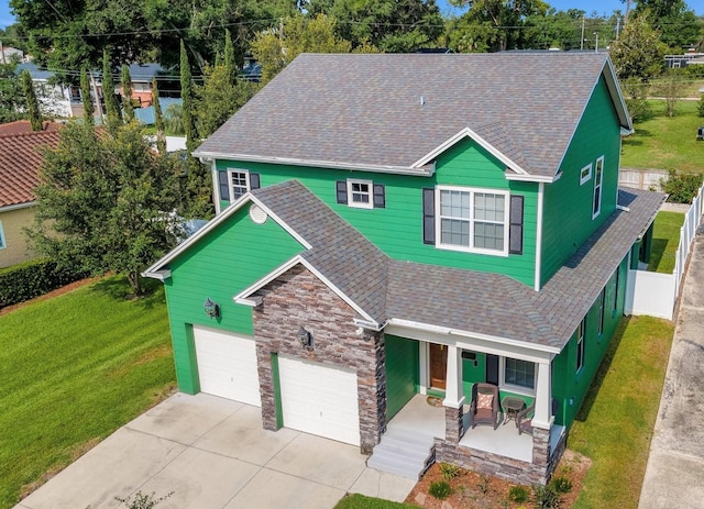 2731 Coventry Ave, Lakeland, FL 33803 - view of front of house with a porch, concrete driveway, a shingled roof, stone siding, and a garage