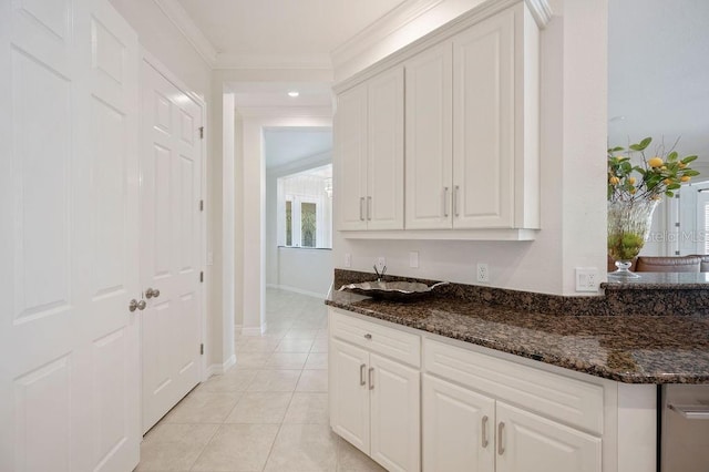 2425 Laurel Glen Dr, Lakeland, FL 33803 - kitchen with white cabinetry, dark stone countertops, light tile patterned floors, and crown molding