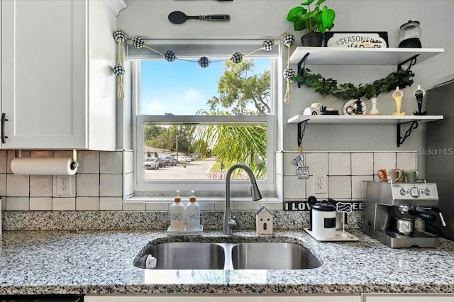 1648 Skinner St, Lakeland, FL 33801 - kitchen featuring a sink, white cabinets, open shelves, tasteful backsplash, and light stone counters