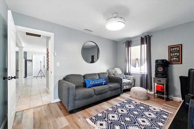 1648 Skinner St, Lakeland, FL 33801 - living room with ornate columns, light wood-type flooring, and baseboards