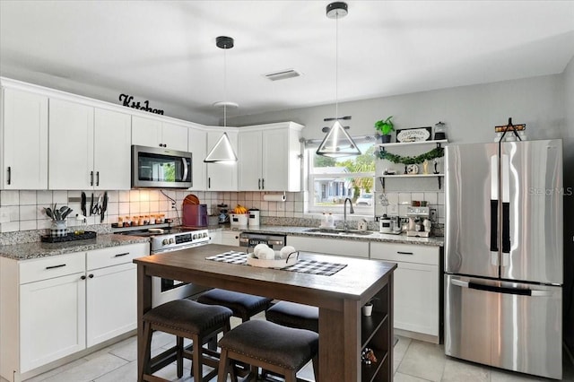 1648 Skinner St, Lakeland, FL 33801 - kitchen featuring appliances with stainless steel finishes, open shelves, a sink, and light tile patterned flooring