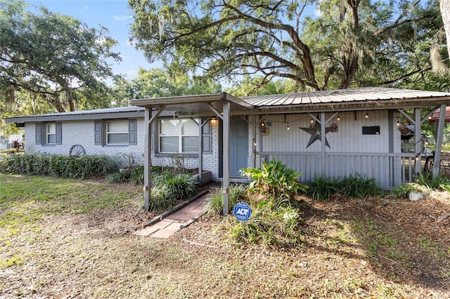 2920 Audie Combee Rd, Lakeland, FL 33801 - view of front of home with covered porch, metal roof, and brick siding