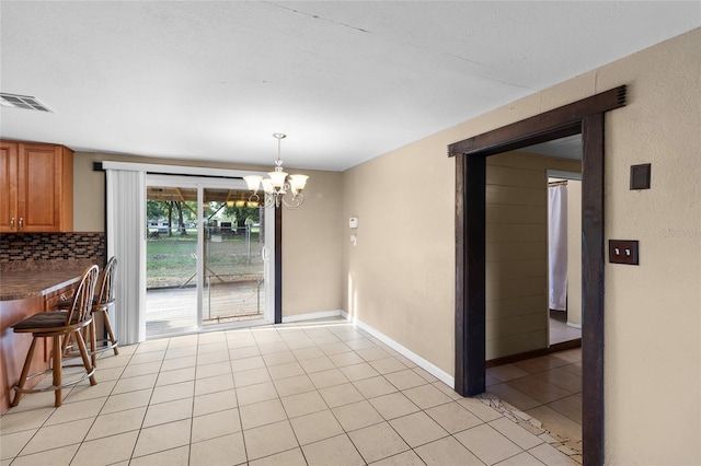 2920 Audie Combee Rd, Lakeland, FL 33801 - unfurnished dining area with a chandelier, light tile patterned floors, and baseboards