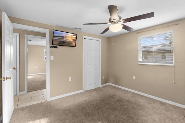 2920 Audie Combee Rd, Lakeland, FL 33801 - unfurnished bedroom featuring light colored carpet, a closet, baseboards, ceiling fan, and light tile patterned floors