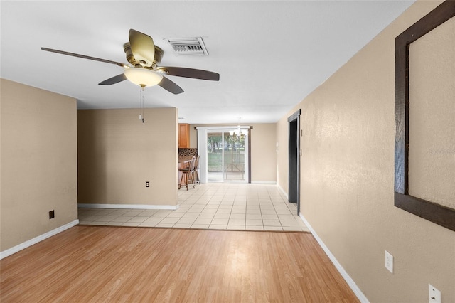 2920 Audie Combee Rd, Lakeland, FL 33801 - empty room with a ceiling fan, baseboards, light wood-type flooring, and a chandelier