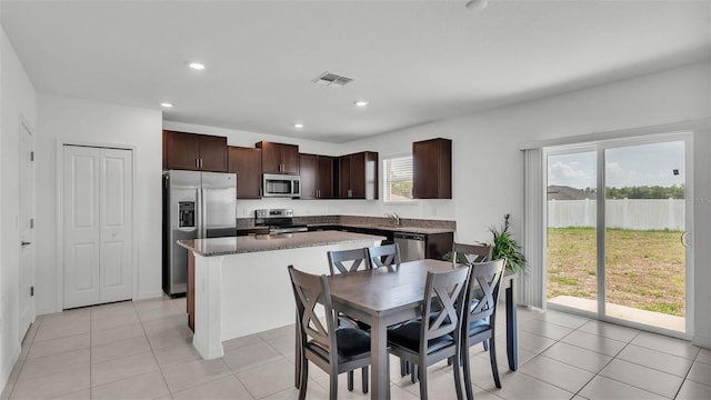 2546 Red Egret Dr, Bartow, FL 33830 - kitchen featuring stainless steel appliances, dark brown cabinets, a kitchen island, a sink, and light tile patterned floors