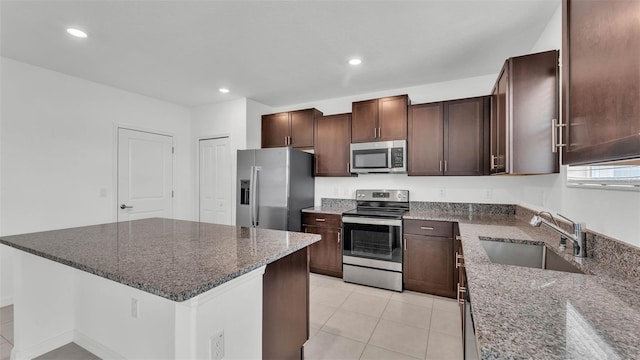 2546 Red Egret Dr, Bartow, FL 33830 - kitchen featuring appliances with stainless steel finishes, a sink, dark stone counters, light tile patterned floors, and recessed lighting