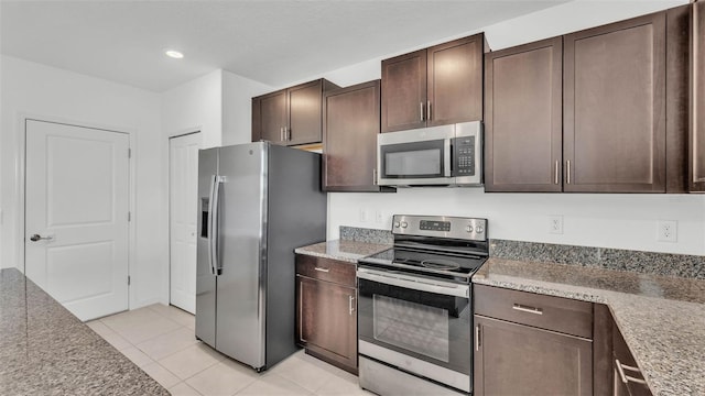 2546 Red Egret Dr, Bartow, FL 33830 - kitchen with appliances with stainless steel finishes, dark brown cabinetry, light tile patterned floors, light countertops, and recessed lighting
