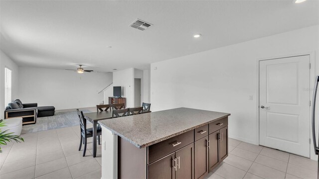 2546 Red Egret Dr, Bartow, FL 33830 - kitchen featuring ceiling fan, light tile patterned floors, dark brown cabinets, a center island, and open floor plan