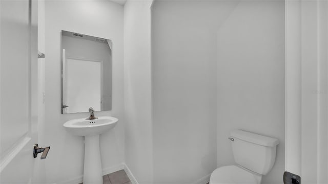 2546 Red Egret Dr, Bartow, FL 33830 - bathroom featuring toilet, a sink, tile patterned floors, and baseboards