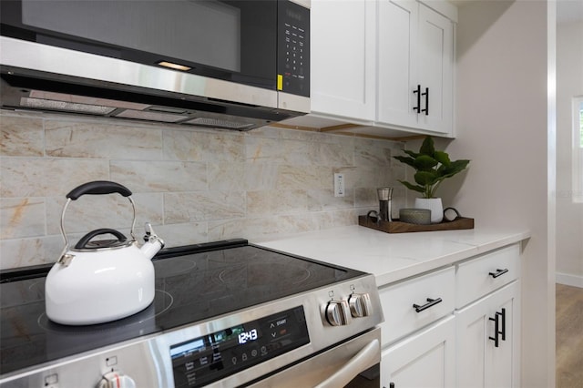 3813 Surrey Dr, Orlando, FL 32812 - kitchen with appliances with stainless steel finishes, white cabinetry, decorative backsplash, and baseboards