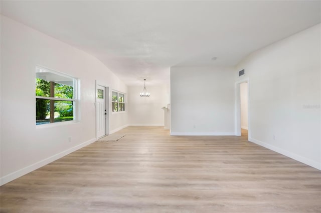 3813 Surrey Dr, Orlando, FL 32812 - unfurnished room with a chandelier, baseboards, light wood-type flooring, and vaulted ceiling